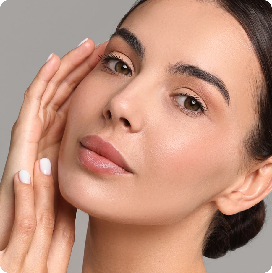 Woman touching her face with hand, displaying clear complexion