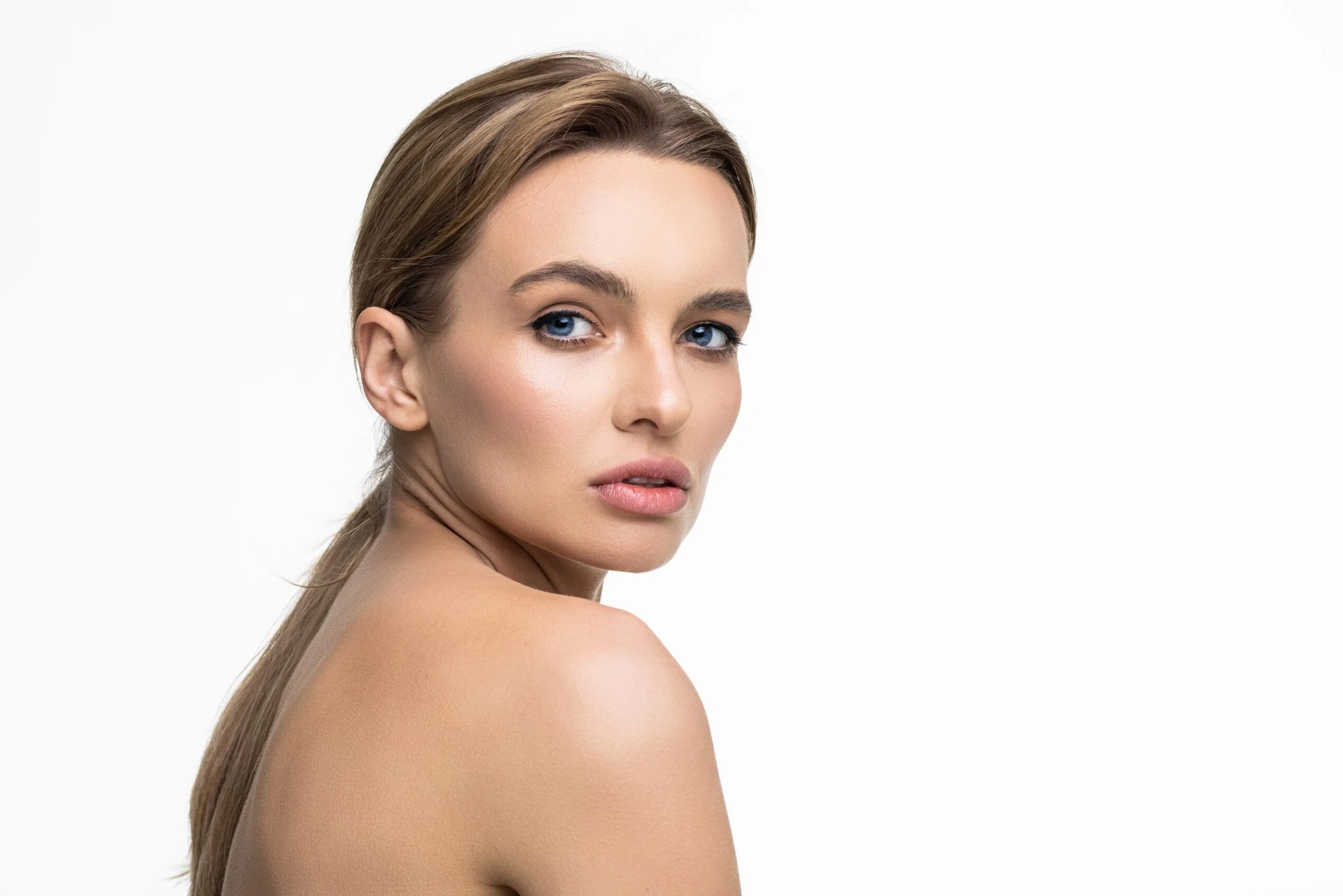 Woman with smooth, radiant skin displayed in profile against a white background