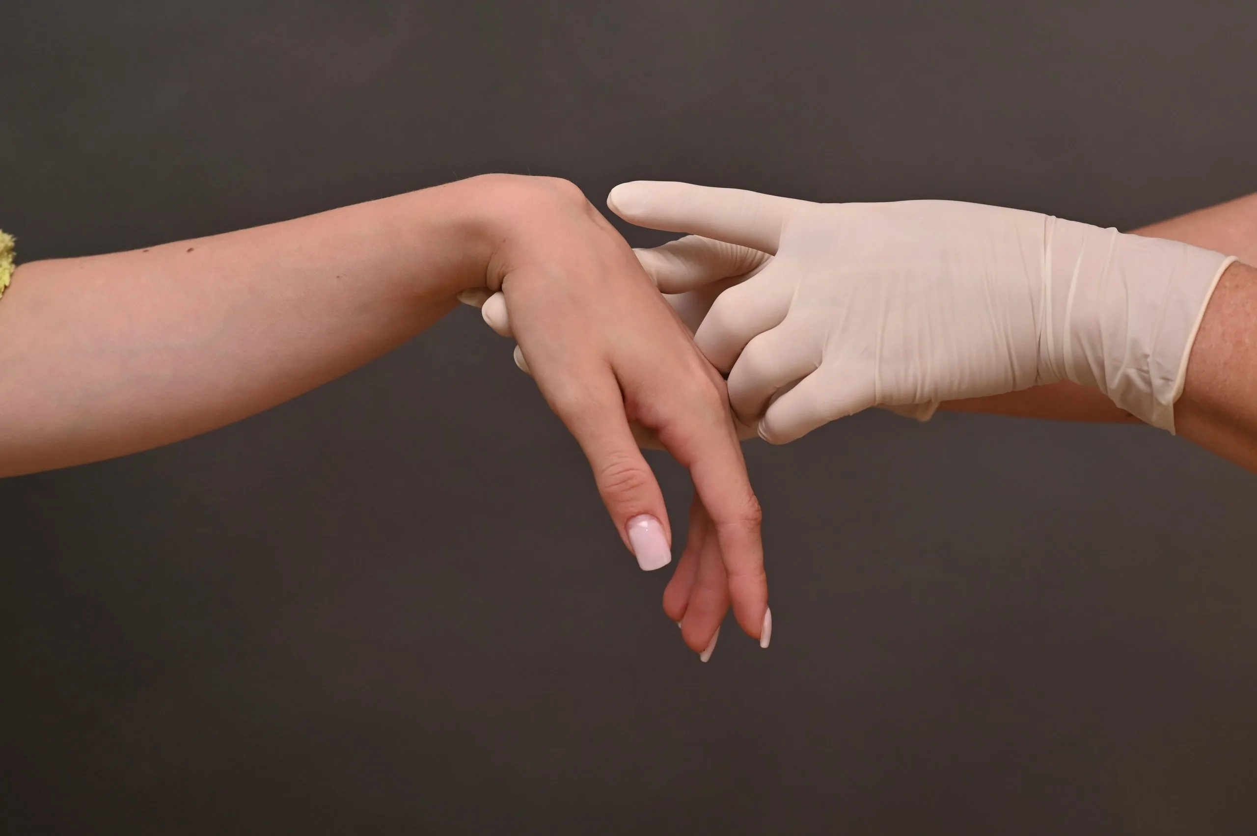 Dermatologist in gloves examining a patient's hand and skin