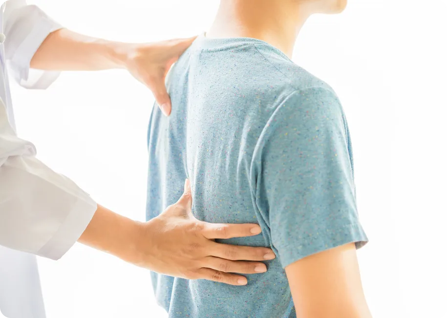 Chiropractor palpating patient's spine and lower back during examination