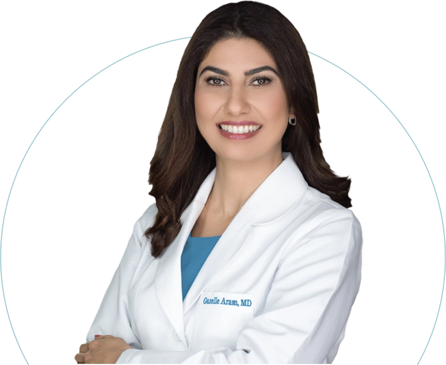 Castelle Arum, MD in white coat and blue top, smiling at camera