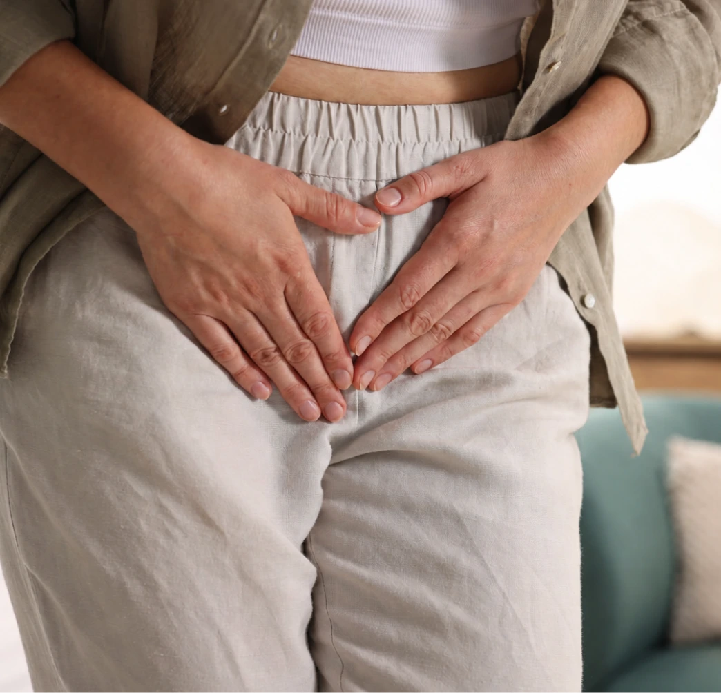 Person holding lower abdomen, indicating bladder discomfort or pain