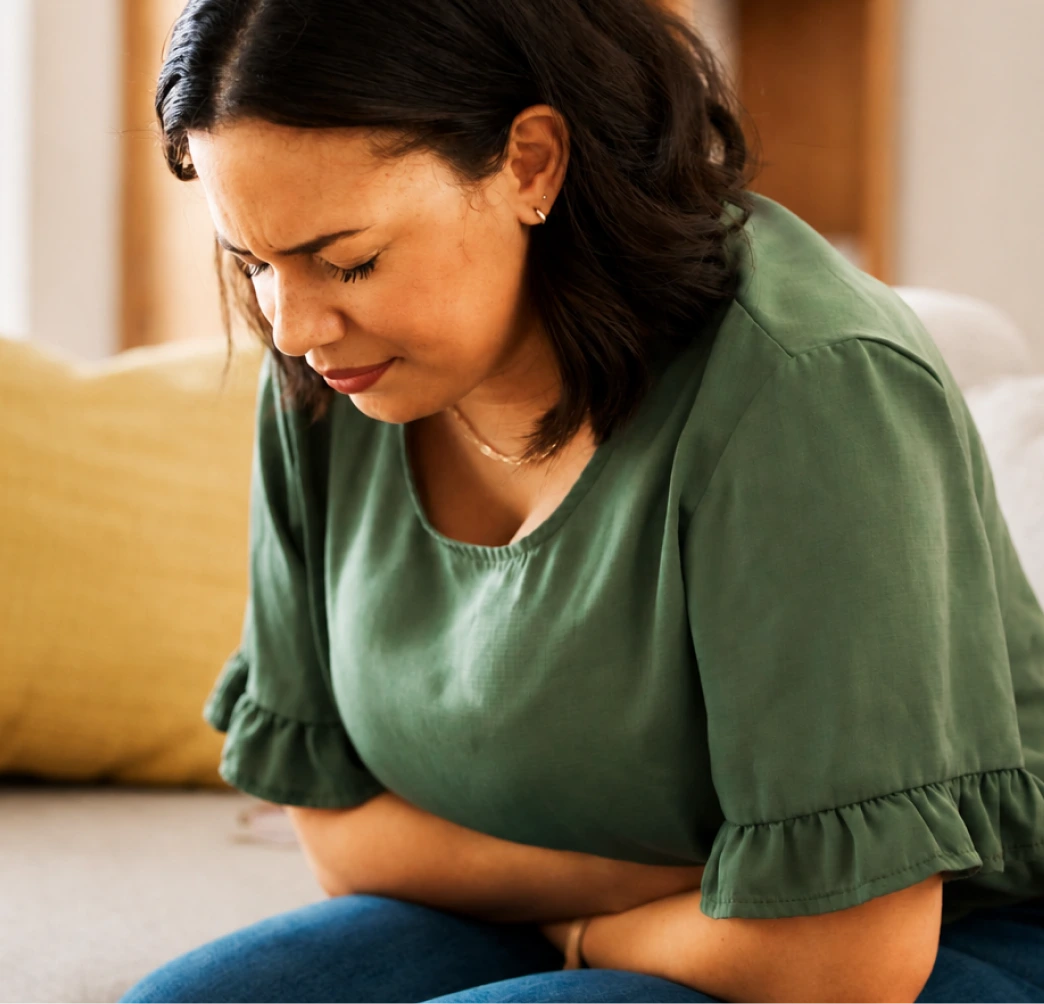 Woman holding her abdomen, experiencing pelvic pain associated with endometriosis