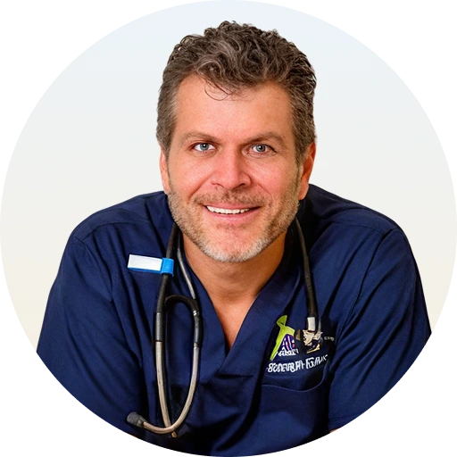 Joseph Gauta MD wearing navy scrubs and stethoscope, smiling at camera