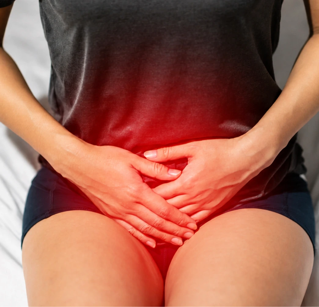 Person holding lower abdomen with red overlay indicating pelvic pain