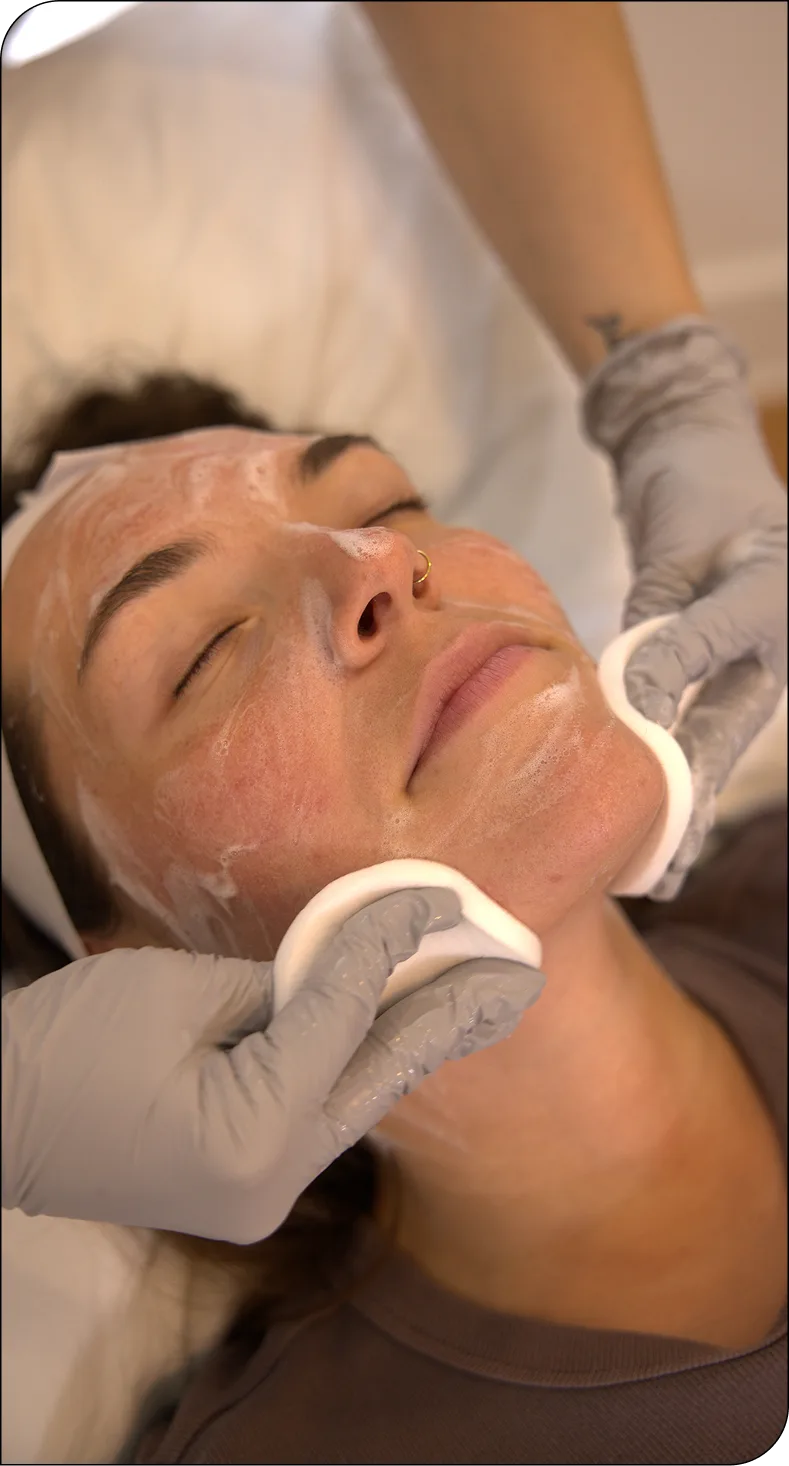 Provider examines patient's face during broken capillary treatment consultation