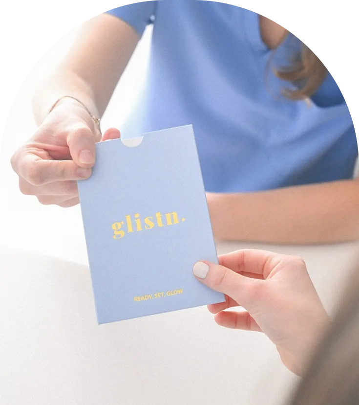 Two hands exchanging Glistn Ready Set Glow gift card in light blue envelope