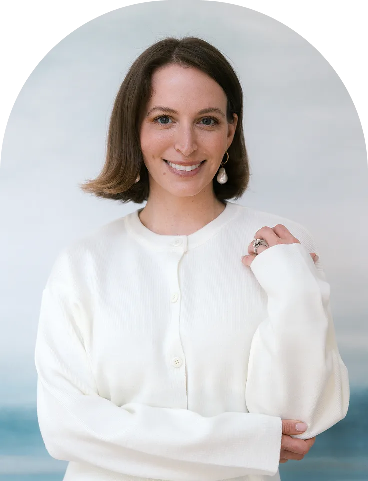 Woman with shoulder-length brown hair smiling at camera, wearing cream button-up