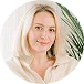 Woman with blonde hair and green plant leaves behind her shoulder