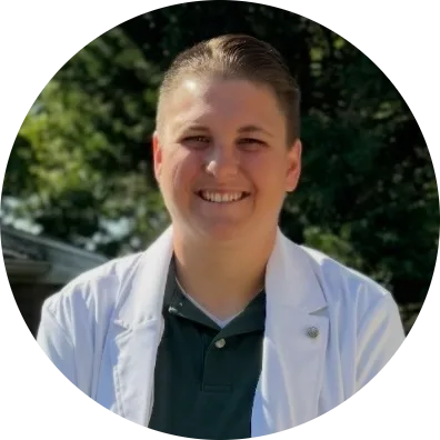 Healthcare provider in white coat and dark polo shirt smiling, circular cropped photo