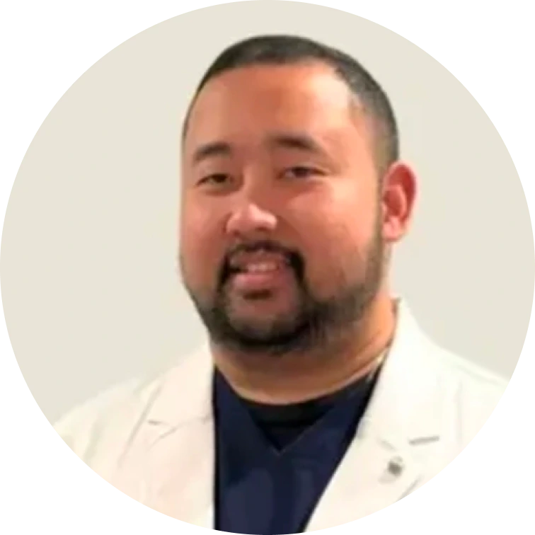Man in white coat and dark shirt, smiling headshot