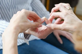 Two people forming a heart shape with their hands together