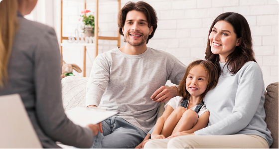 Family of three smiling at healthcare provider during a consultation