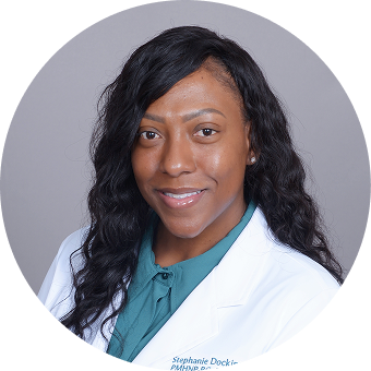 Stephanie Deck, healthcare provider, wearing white coat and teal shirt