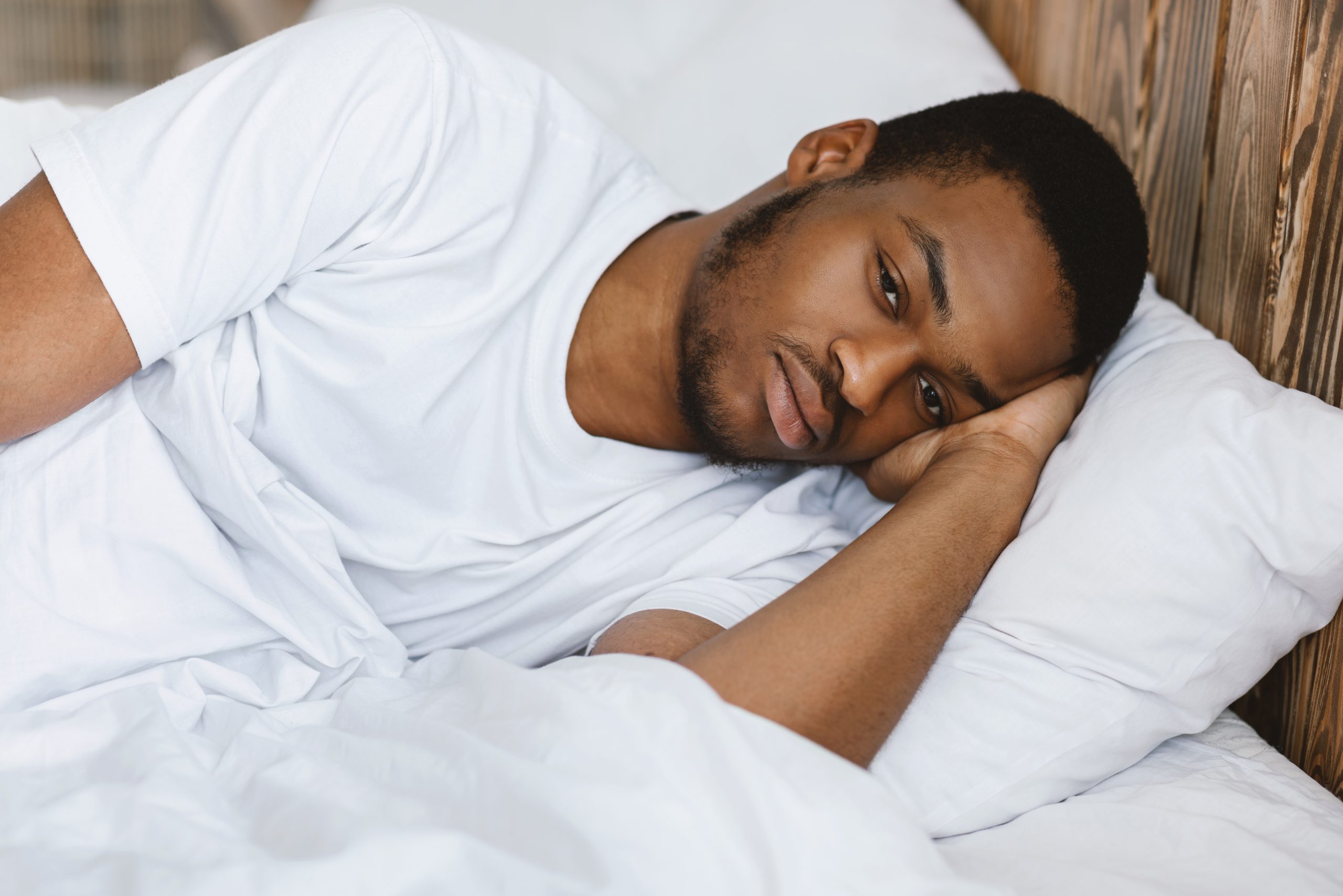 Depressedafricanamericanmanlyingawakethinkingofproblemsand