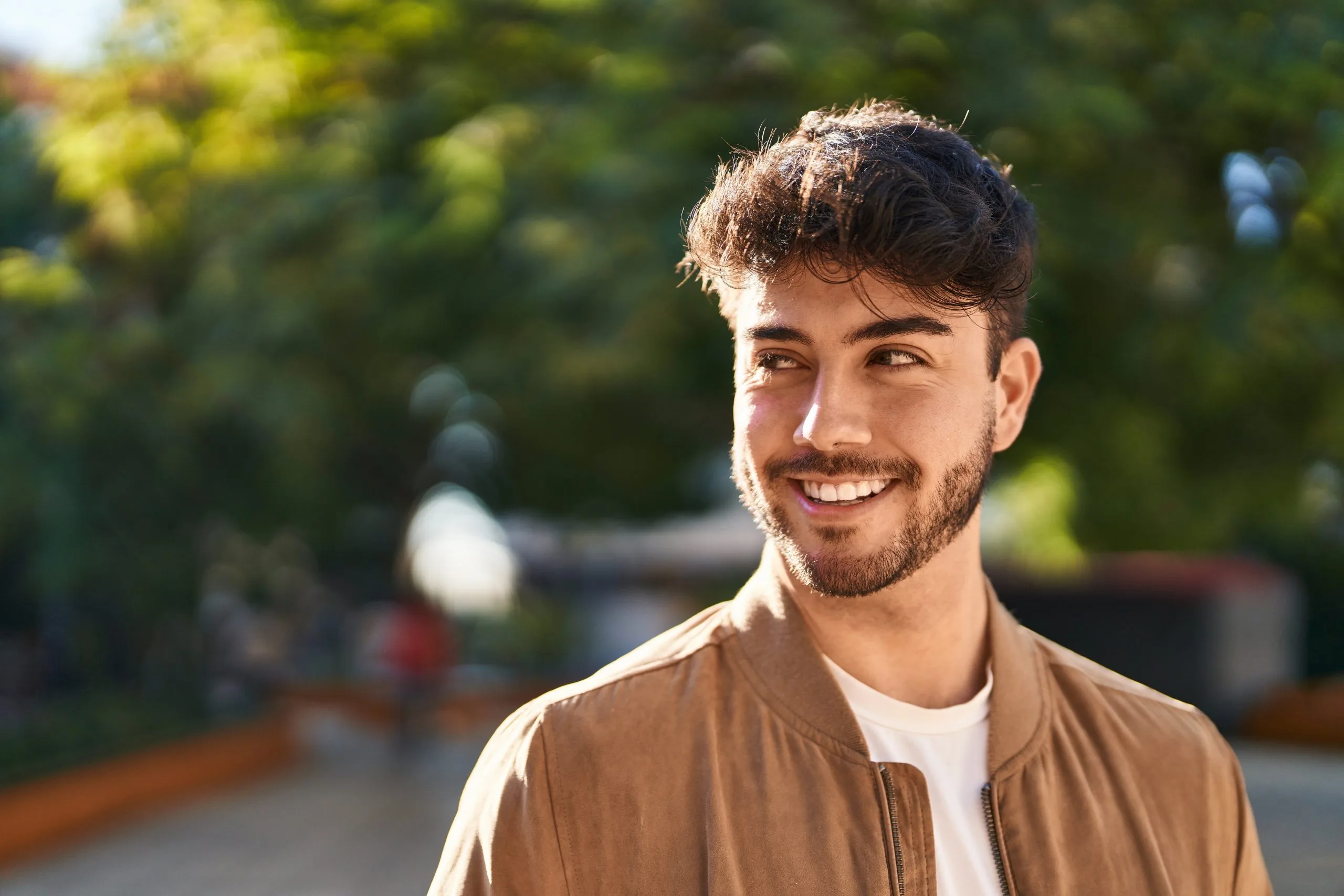 Younghispanicmansmilingconfidentlookingtothesideat