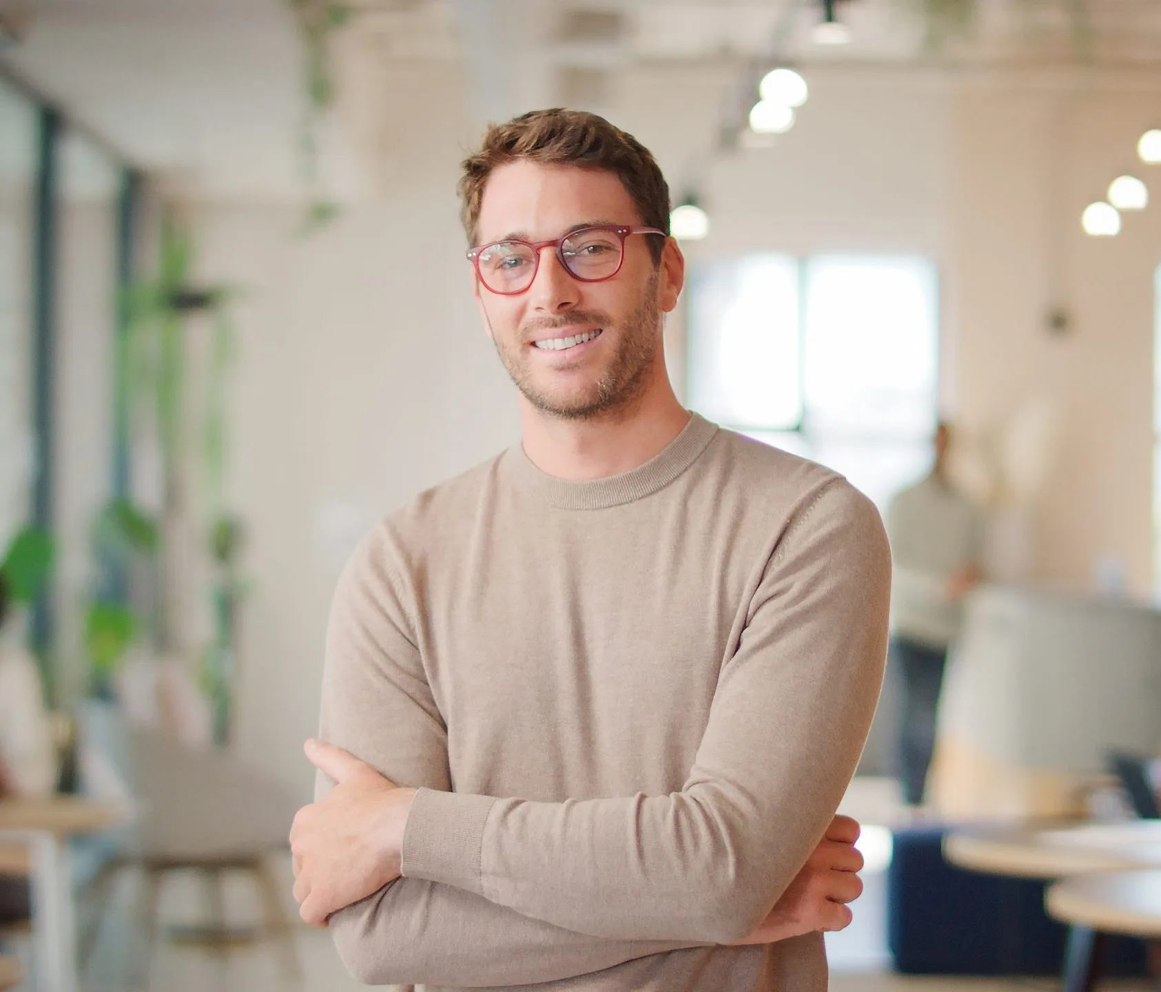 Portraitofsmilingbusinessmanwearingglassesstandinginbusymodern