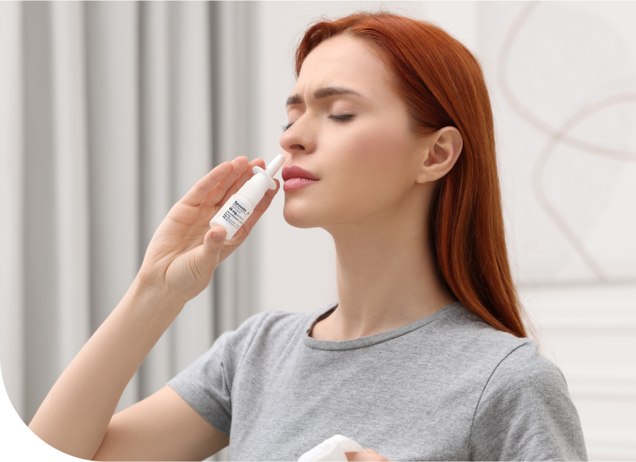 Woman administering Spravato nasal spray to herself with eyes closed