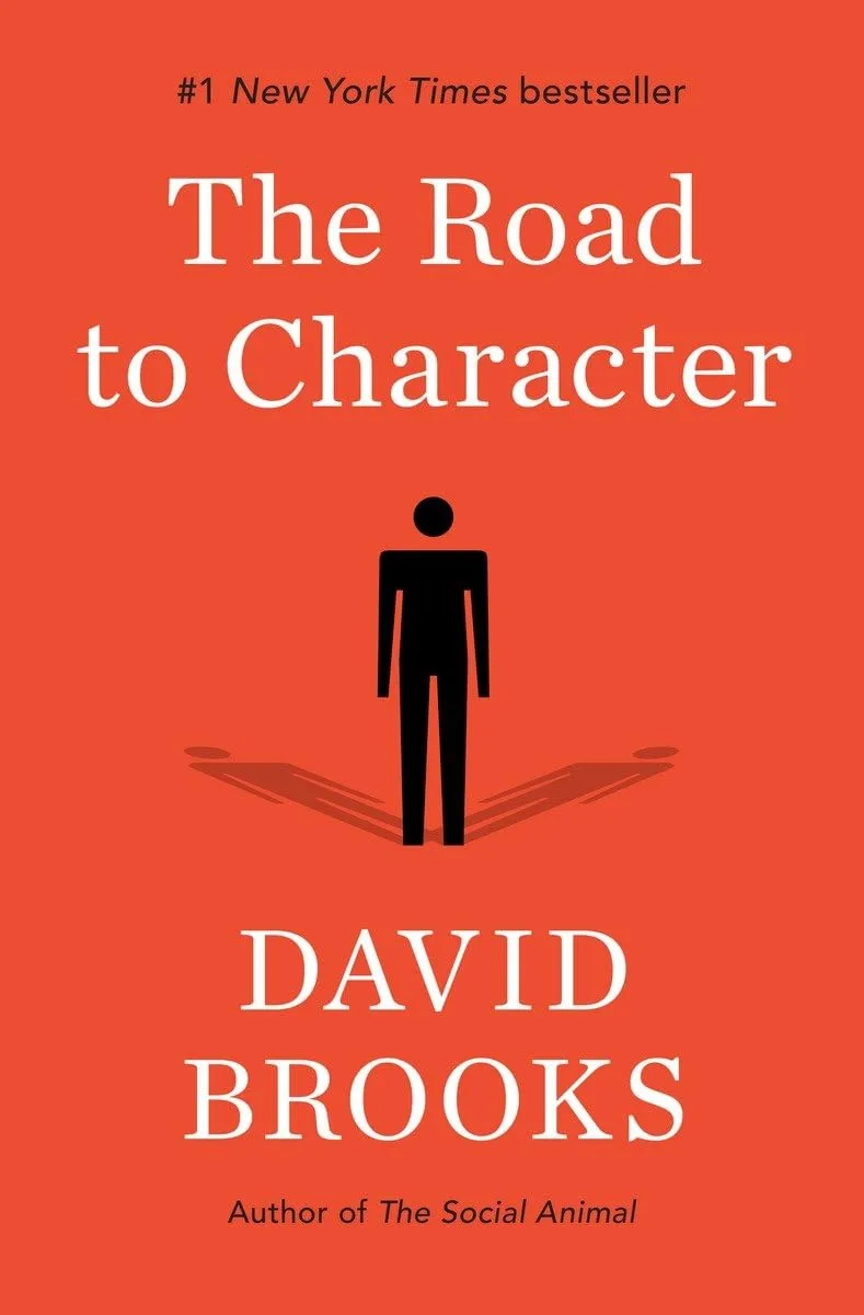 "The Road to Character" by David Brooks, #1 New York Times bestseller, featuring a black silhouette of a standing figure on an orange-red background