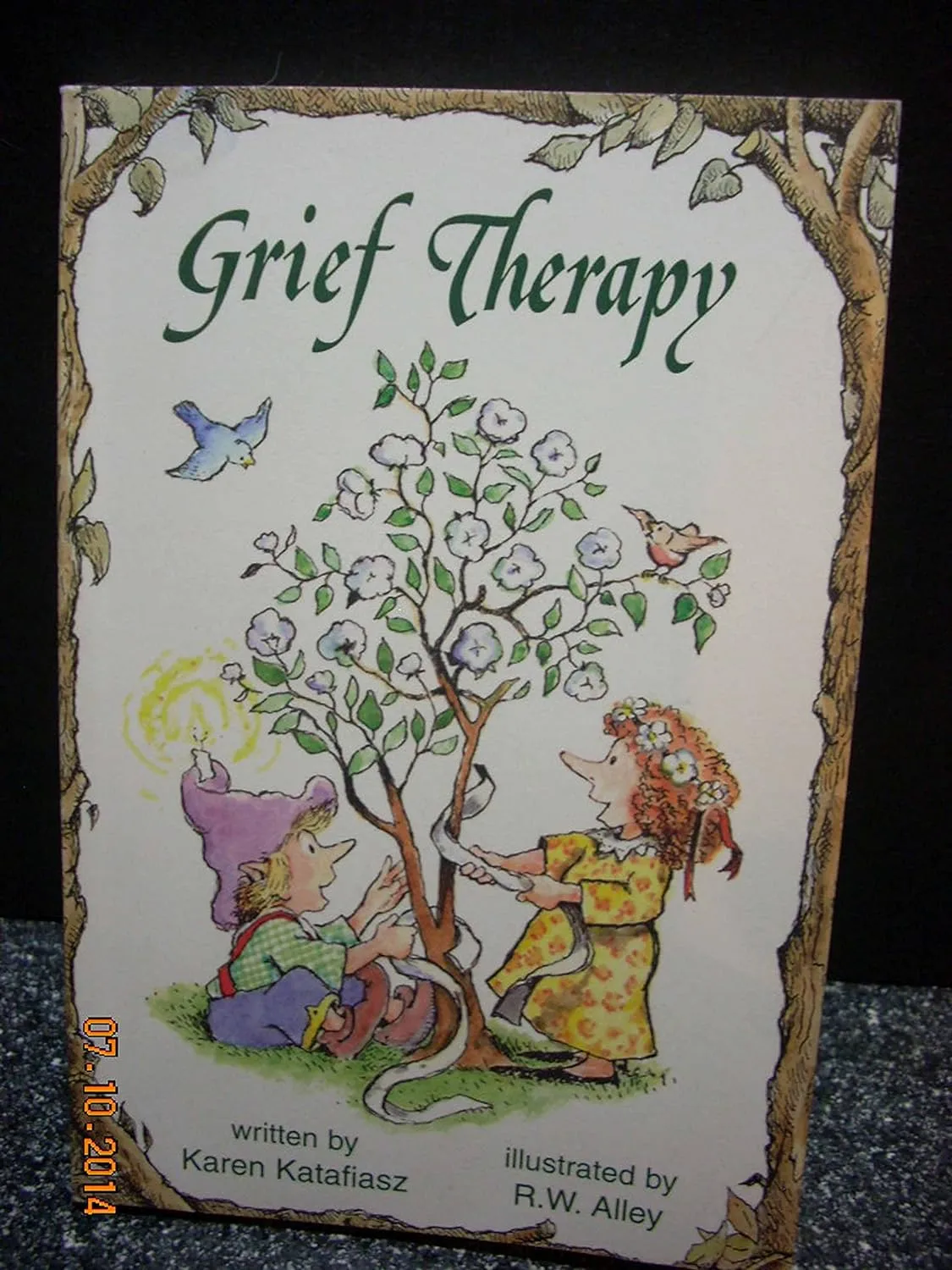 Grief Therapy book cover depicting two children tending to a flowering tree with birds flying nearby, written by Karen Katafiasz and illustrated by R.W. Alley