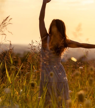 Woman outdoors in a sunlit field, representing holistic mental health support