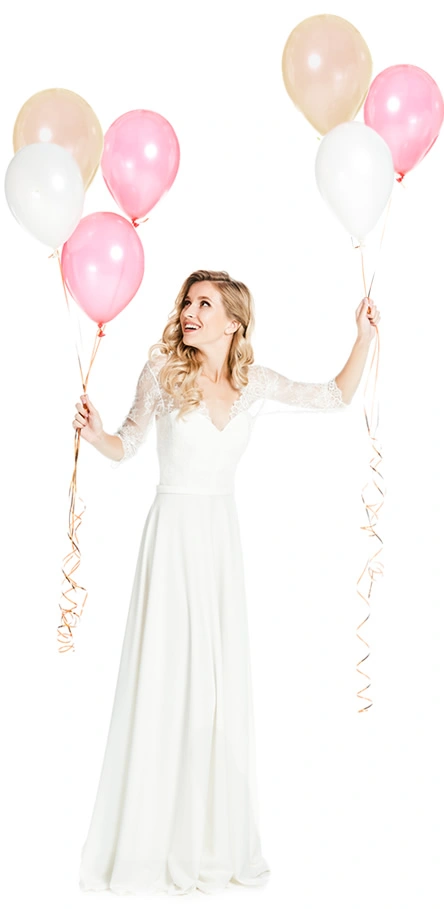 Woman in white dress holding pink and cream balloons at a bachelorette party