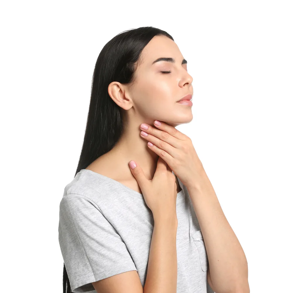 Woman palpating her own neck area, examining thyroid region