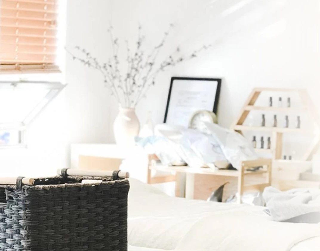 Minimalist spa studio shelf with dried flowers, framed art, wooden organizers, and product bottles