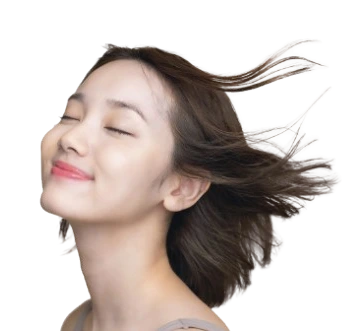Woman with eyes closed and hair flowing, relaxed expression during scalp treatment