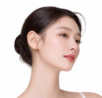 Woman with dark hair in updo showing profile with clear complexion and natural makeup
