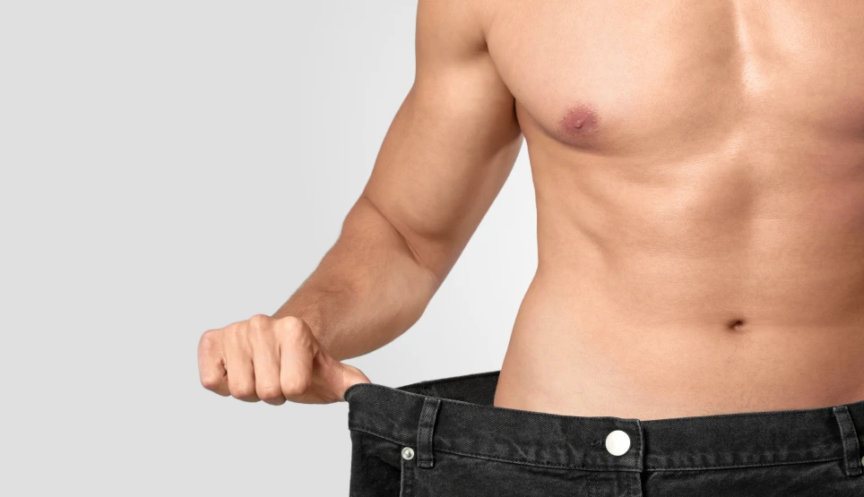 Man pinching abdominal skin to demonstrate body contouring results