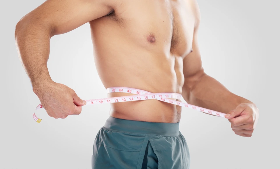 Man measuring waist with pink measuring tape to show weight loss results