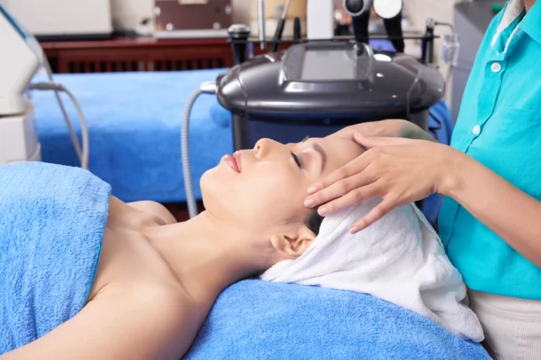 Provider administering a facial treatment to a relaxed patient in a clinical treatment room