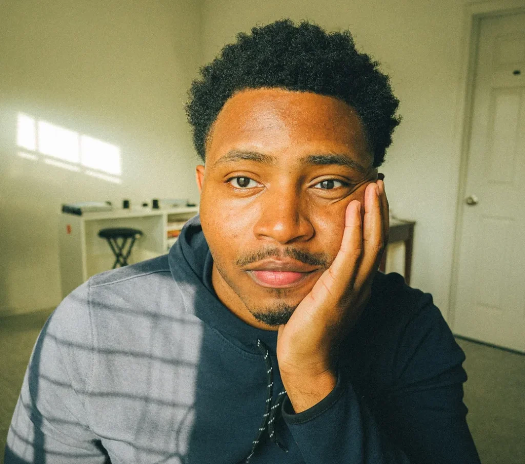 Man resting his face in his hand, looking thoughtful
