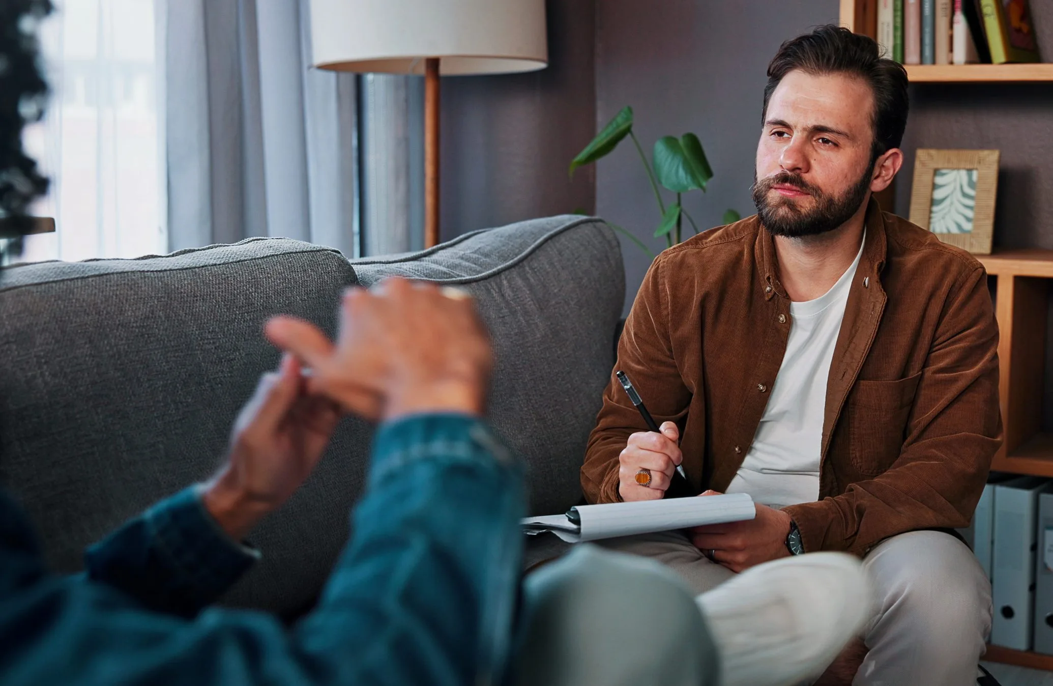 Therapist listening to a client during a psychiatric counseling session in an office setting