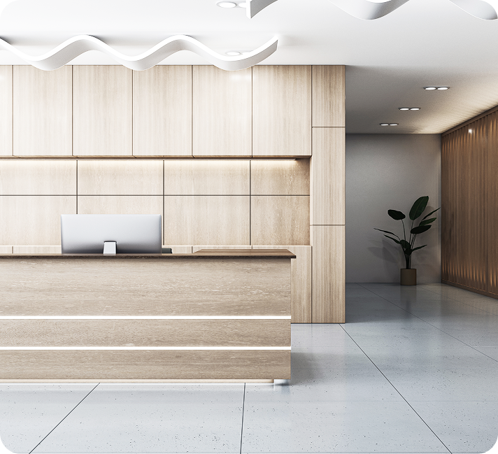 Modern medical office reception desk with light wood paneling, computer workstation, and minimalist interior design