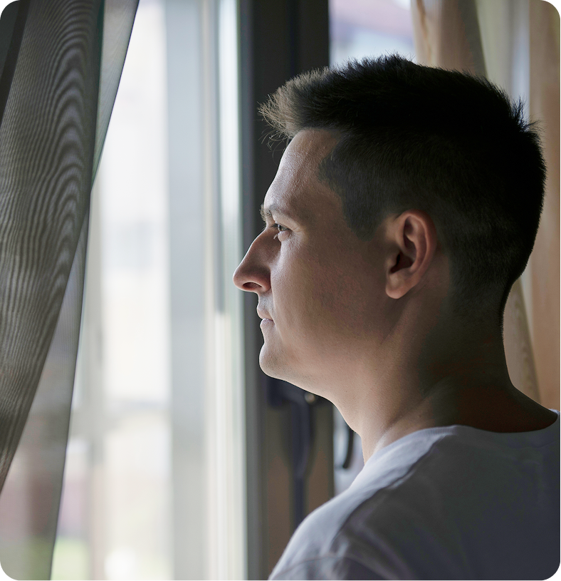 Man in profile looking out window with concerned expression