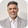 Man with glasses wearing light-colored shirt in headshot portrait