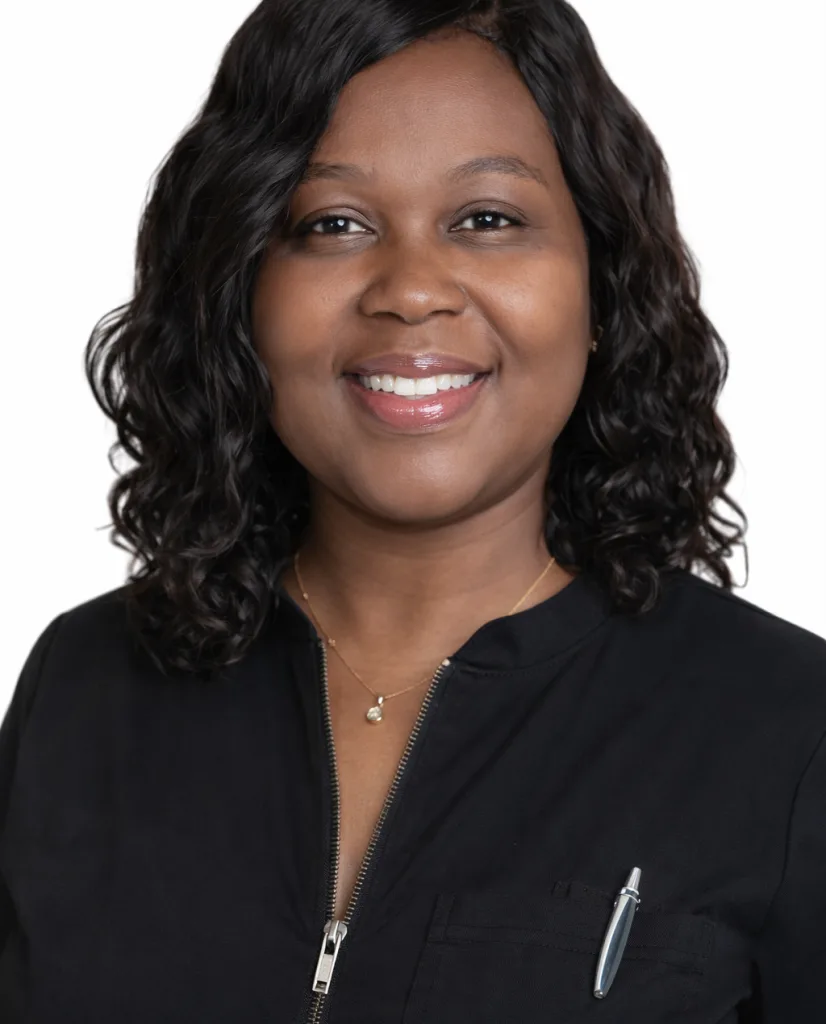 Regine Blaise, woman in black medical jacket with pen in pocket