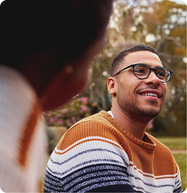 Two men conversing outdoors in a garden setting
