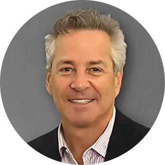 Professional headshot of a male podiatrist with gray hair wearing a dark blazer and striped shirt