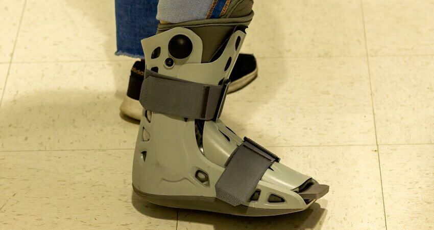 Person wearing orthopedic ankle boot after surgery