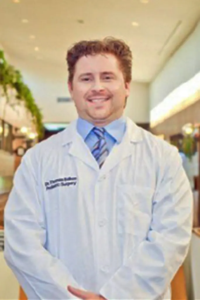 Podiatrist in white coat and blue tie in clinical setting