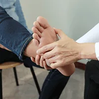 Healthcare provider examining patient's foot during consultation