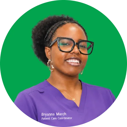 Bryanna March, Patient Care Coordinator, smiling at camera wearing purple scrubs and glasses