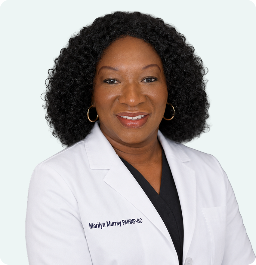 Marilyn Murray, PMHNP-BC, smiling in white medical coat against neutral background