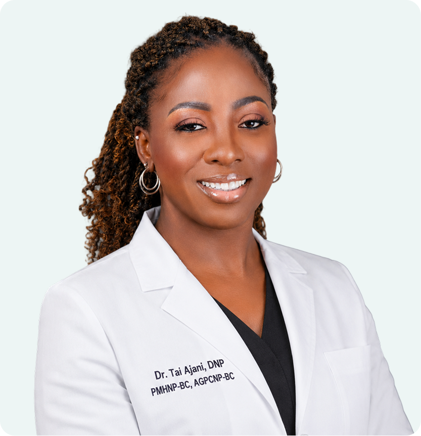 Dr. Tai Ajani, DNP, PMHNP-BC, AGPCNP-BC, smiling in white medical coat against neutral background