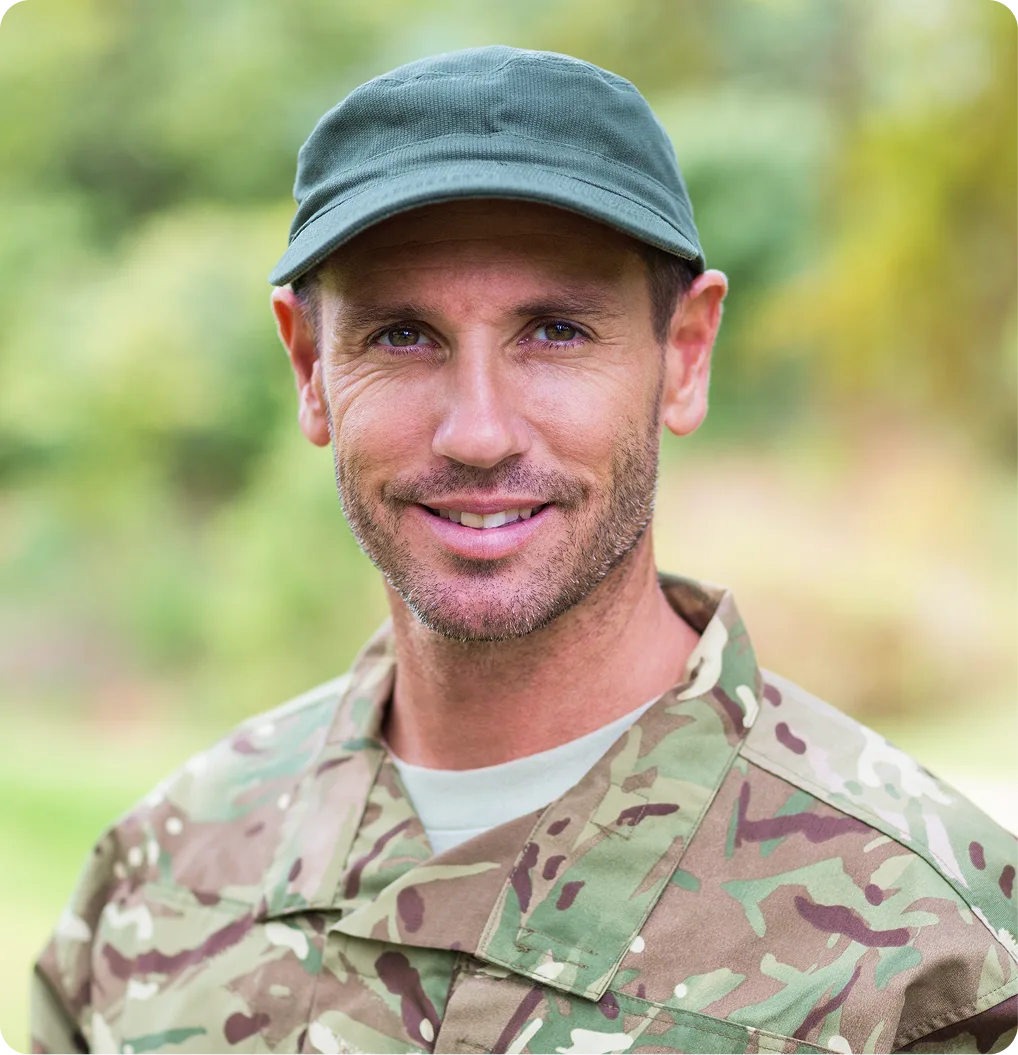 Military service member in camouflage uniform smiling outdoors