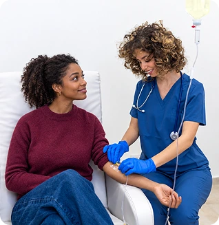 Healthcare provider in blue scrubs administering IV therapy to a patient at MindBodyPinnacle Health's Laurel, MD location
