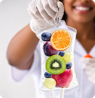 Healthcare provider in gloves holding an IV bag filled with colorful fruits and vegetables